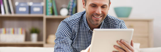 Mand der sidder med en tablet